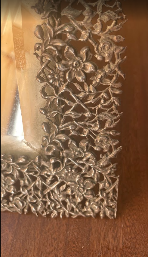 Tabletop vanity mirror with a richly decorated metal frame