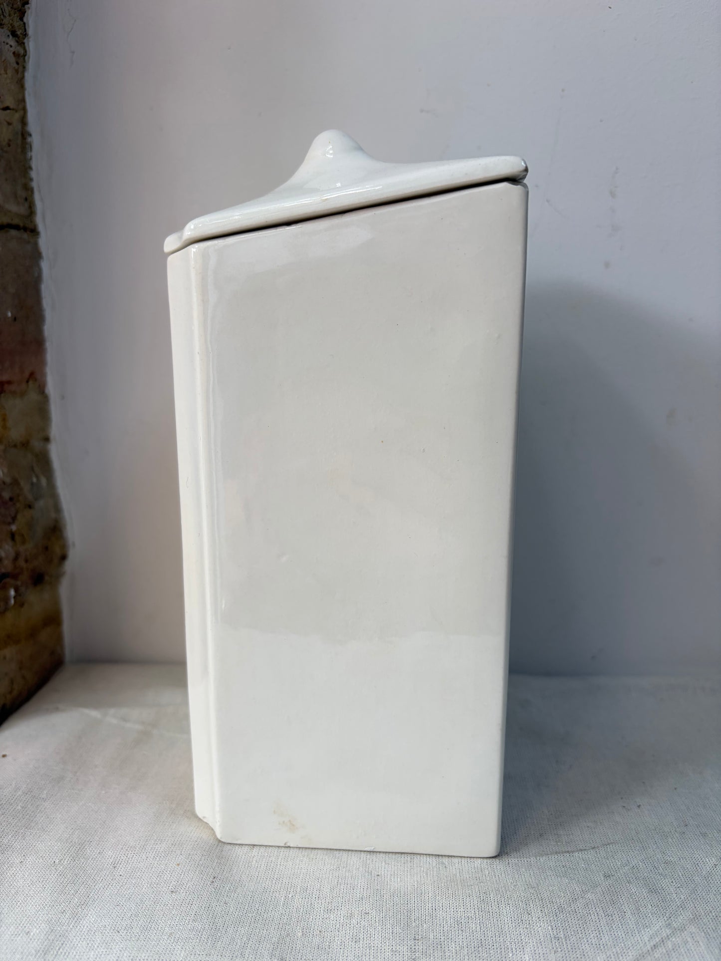 A pair of white kitchen storage jars  with blue decorative borders and labels reading 'OATMEAL' and 'FLOUR'. 